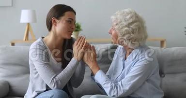 有爱心的年轻女子孙女牵着<strong>老奶奶</strong>的手说着话